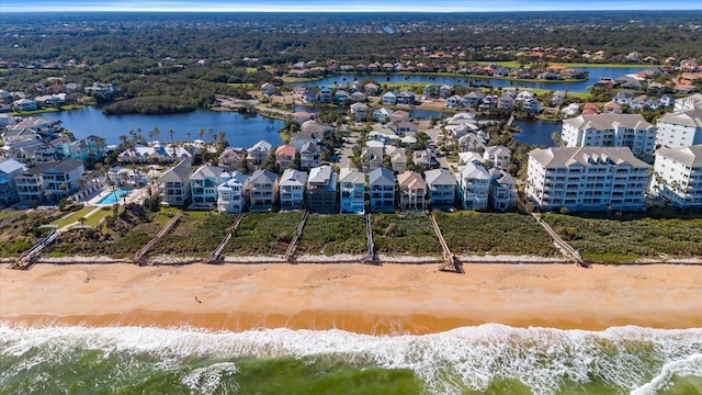 drone / aerial view featuring a beach view and a water view