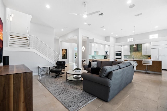 tiled living room featuring ceiling fan and sink