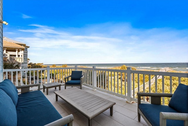 exterior space with an outdoor living space, a water view, and a beach view