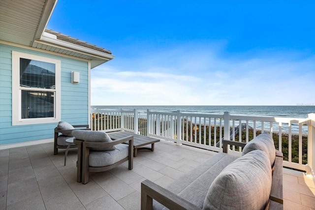 view of patio with outdoor lounge area, a water view, and a view of the beach