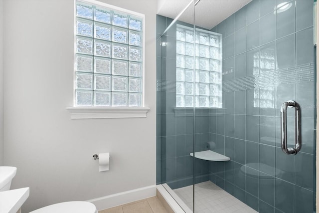 bathroom featuring tile patterned flooring, toilet, and an enclosed shower