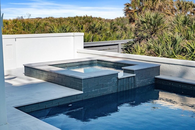 view of swimming pool with an in ground hot tub