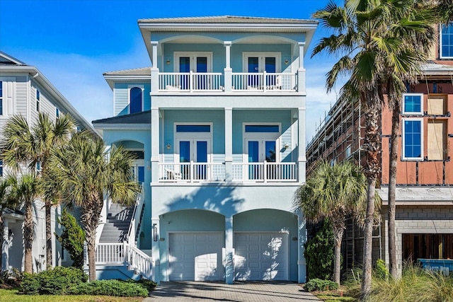 beach home featuring a balcony, french doors, and a garage