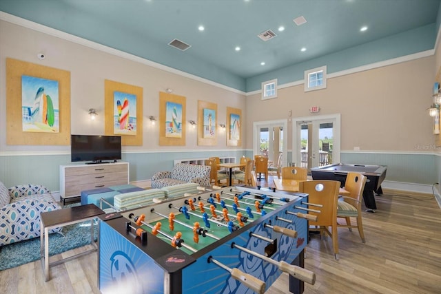 playroom with french doors, light hardwood / wood-style floors, and a high ceiling