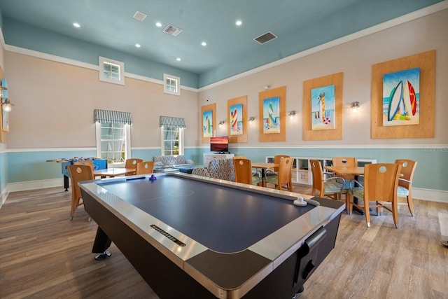 playroom featuring light hardwood / wood-style floors and a high ceiling