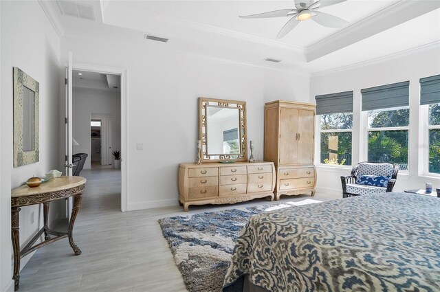 bedroom with crown molding, ceiling fan, and a tray ceiling