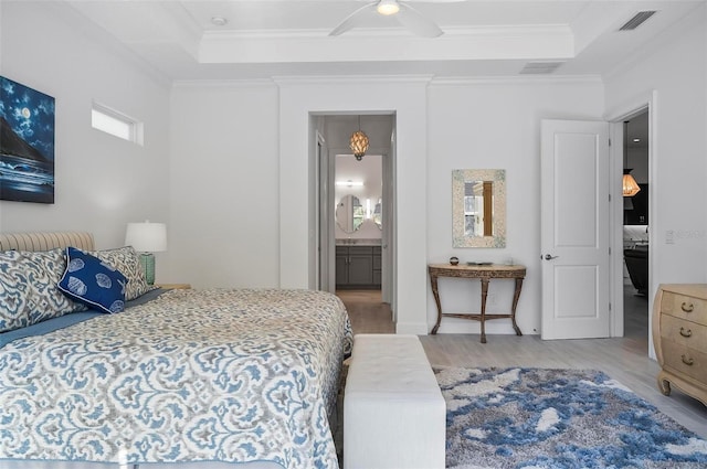 bedroom with hardwood / wood-style flooring, crown molding, ceiling fan, and ensuite bath