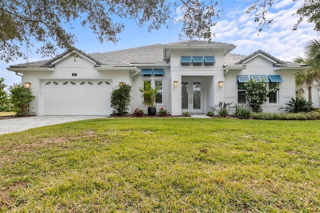 view of front of house featuring french doors, a garage, and a front lawn