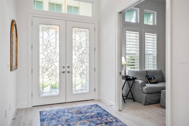 foyer entrance with light hardwood / wood-style floors and french doors