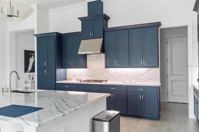 kitchen with light stone counters, sink, tasteful backsplash, and blue cabinetry