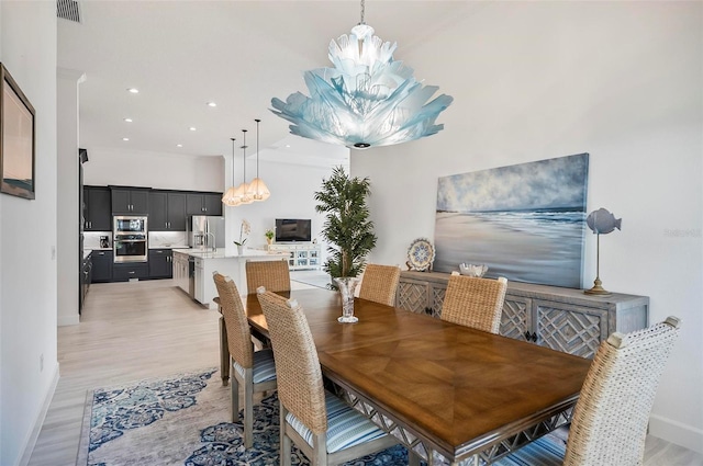 dining room featuring a chandelier and light wood-type flooring