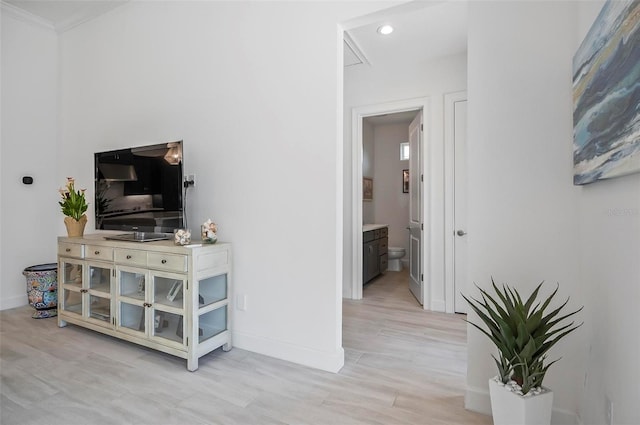 living room with crown molding and light wood-type flooring