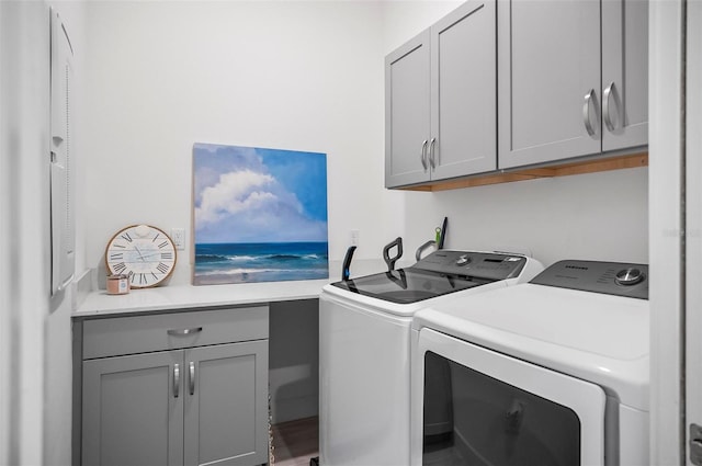 washroom with cabinets and washer and dryer