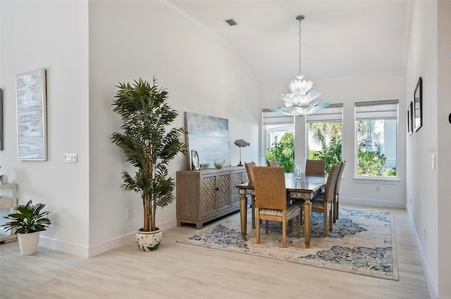 dining space with ornamental molding, light hardwood / wood-style floors, and a notable chandelier