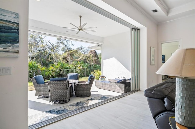 interior space featuring plenty of natural light, ornamental molding, and ceiling fan