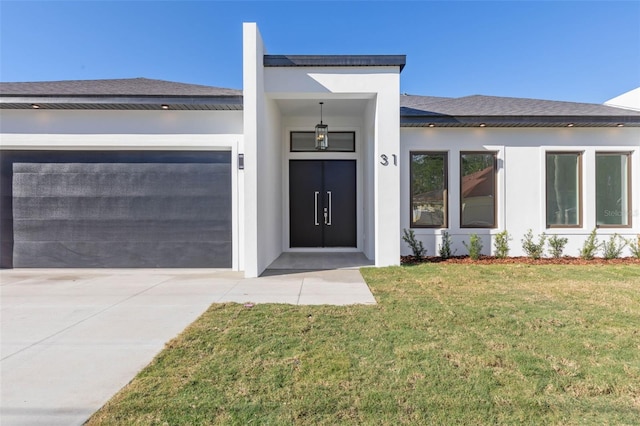 view of exterior entry with a lawn and a garage