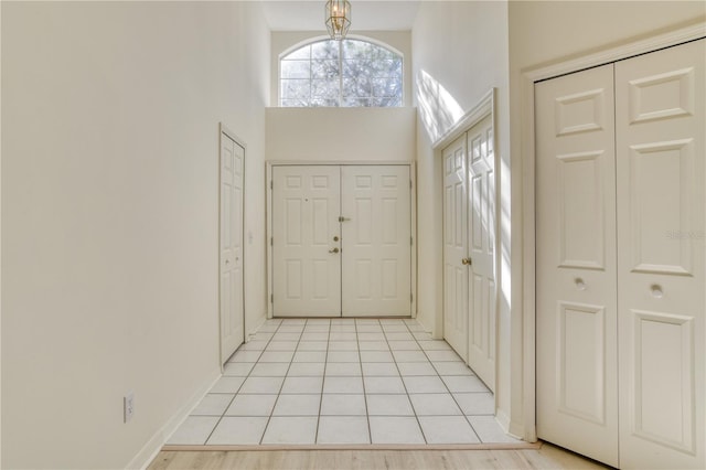 entrance foyer featuring a high ceiling, light wood-type flooring, and a notable chandelier