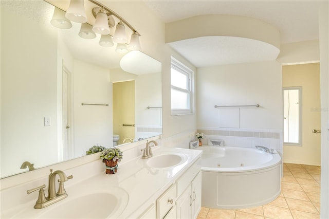 bathroom with a washtub, vanity, a textured ceiling, tile patterned flooring, and toilet