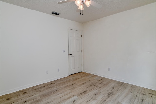 spare room with a textured ceiling, light hardwood / wood-style flooring, and ceiling fan