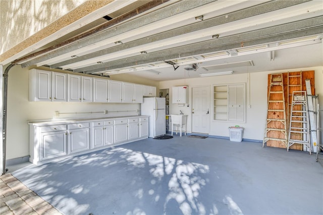 garage with white fridge, sink, and a garage door opener