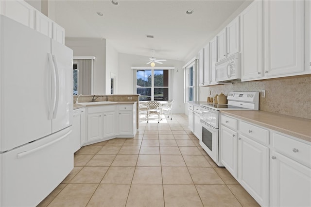 kitchen with lofted ceiling, white appliances, decorative backsplash, ceiling fan, and white cabinetry