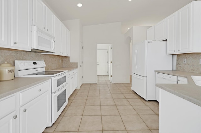 kitchen featuring tasteful backsplash, white cabinetry, and white appliances