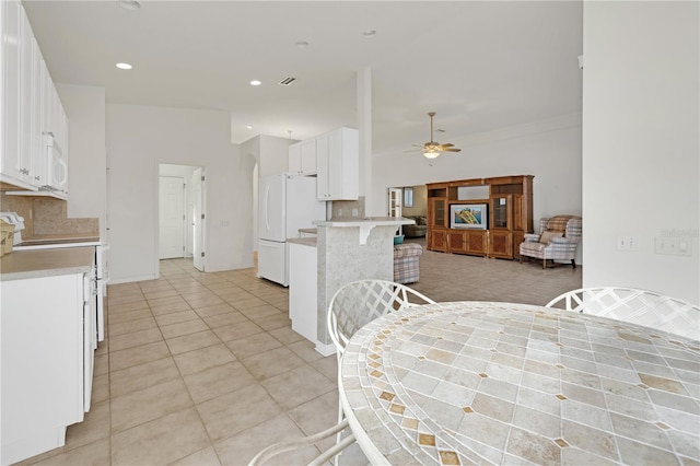 dining room with ceiling fan, crown molding, and light tile patterned flooring