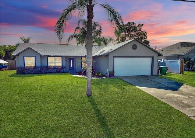 ranch-style home with a garage and a lawn