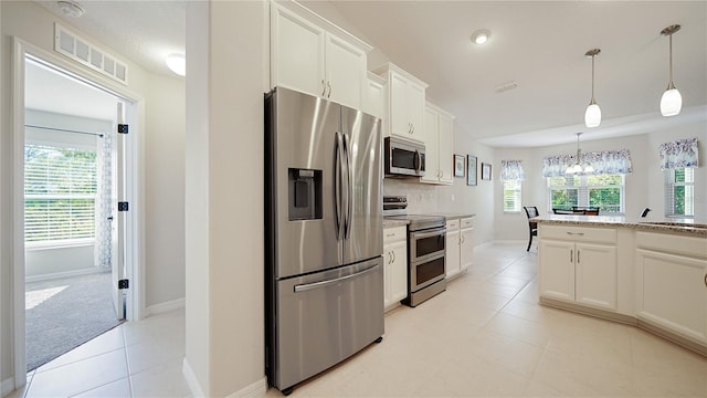 kitchen featuring light carpet, light stone counters, stainless steel appliances, pendant lighting, and white cabinets