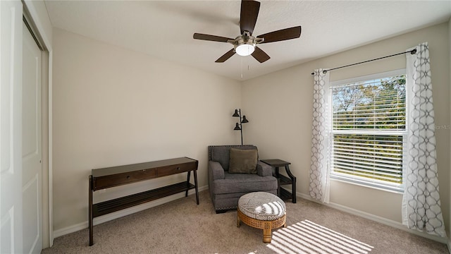 sitting room with ceiling fan and light carpet