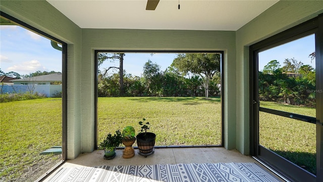 unfurnished sunroom with ceiling fan