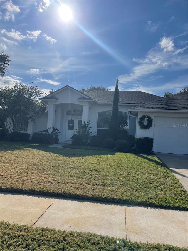 single story home with a front yard and a garage