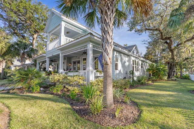 view of property exterior featuring a yard, a balcony, and ceiling fan