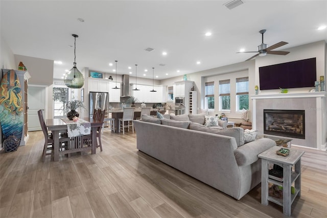 living room with recessed lighting, light wood-type flooring, visible vents, and a healthy amount of sunlight