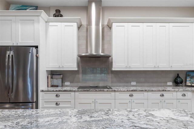 35 Smiling Fish Ln, Palm Coast, FL 32137 - kitchen featuring freestanding refrigerator, wall chimney range hood, black electric stovetop, and backsplash