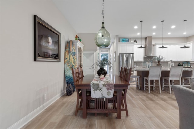 dining room featuring light wood-style flooring, baseboards, and recessed lighting