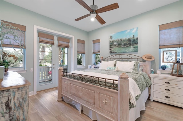 bedroom featuring light wood-type flooring, access to outside, multiple windows, and ceiling fan