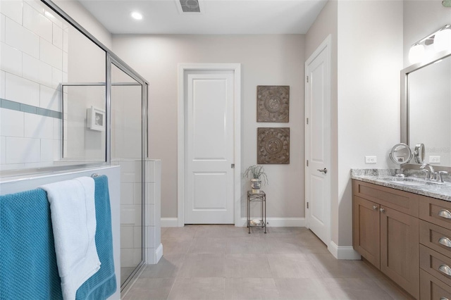 bathroom with visible vents, a shower with shower door, vanity, and baseboards