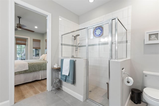 ensuite bathroom with a stall shower, ceiling fan, toilet, and ensuite bathroom