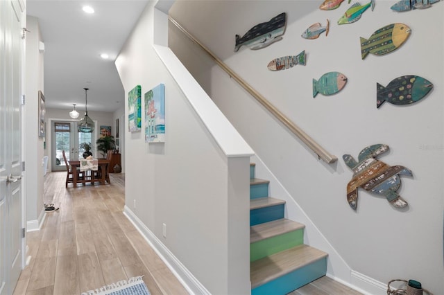 stairs with recessed lighting, wood finished floors, and baseboards