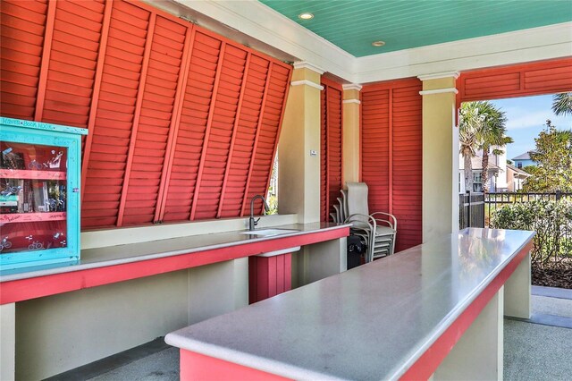 35 Smiling Fish Ln, Palm Coast, FL 32137 - kitchen featuring stainless steel counters, a sink, carpet, recessed lighting, and decorative columns
