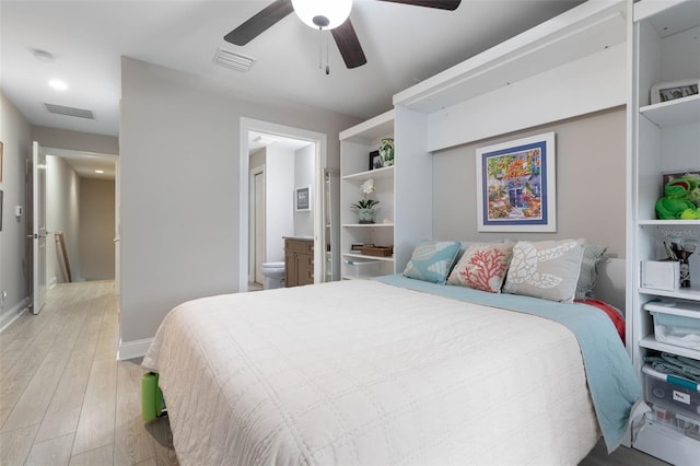 bedroom with visible vents, ensuite bath, light wood-style flooring, and baseboards