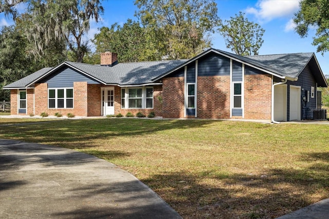 ranch-style home featuring a garage, central air condition unit, and a front lawn