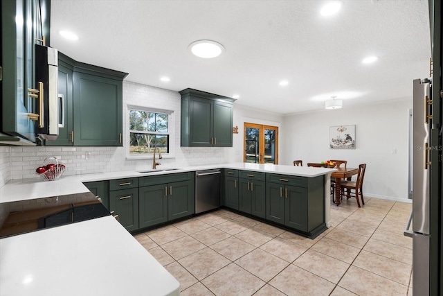 kitchen with sink, stainless steel appliances, kitchen peninsula, light tile patterned floors, and green cabinetry