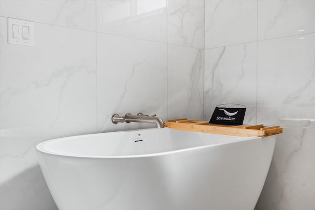 bathroom featuring a bathing tub and tile walls