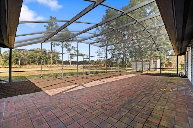 view of patio / terrace with a lanai and a shed