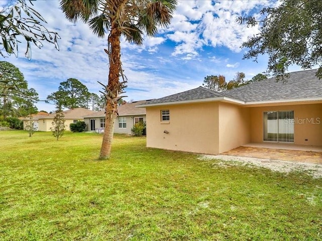 rear view of house with a yard and a patio