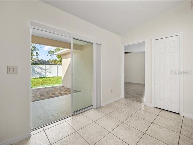 interior space featuring light tile patterned flooring and vaulted ceiling