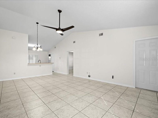 unfurnished living room featuring ceiling fan with notable chandelier, sink, light tile patterned floors, and vaulted ceiling