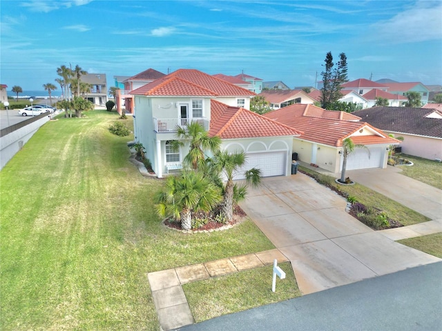 view of front of home with a front yard, a garage, and a balcony